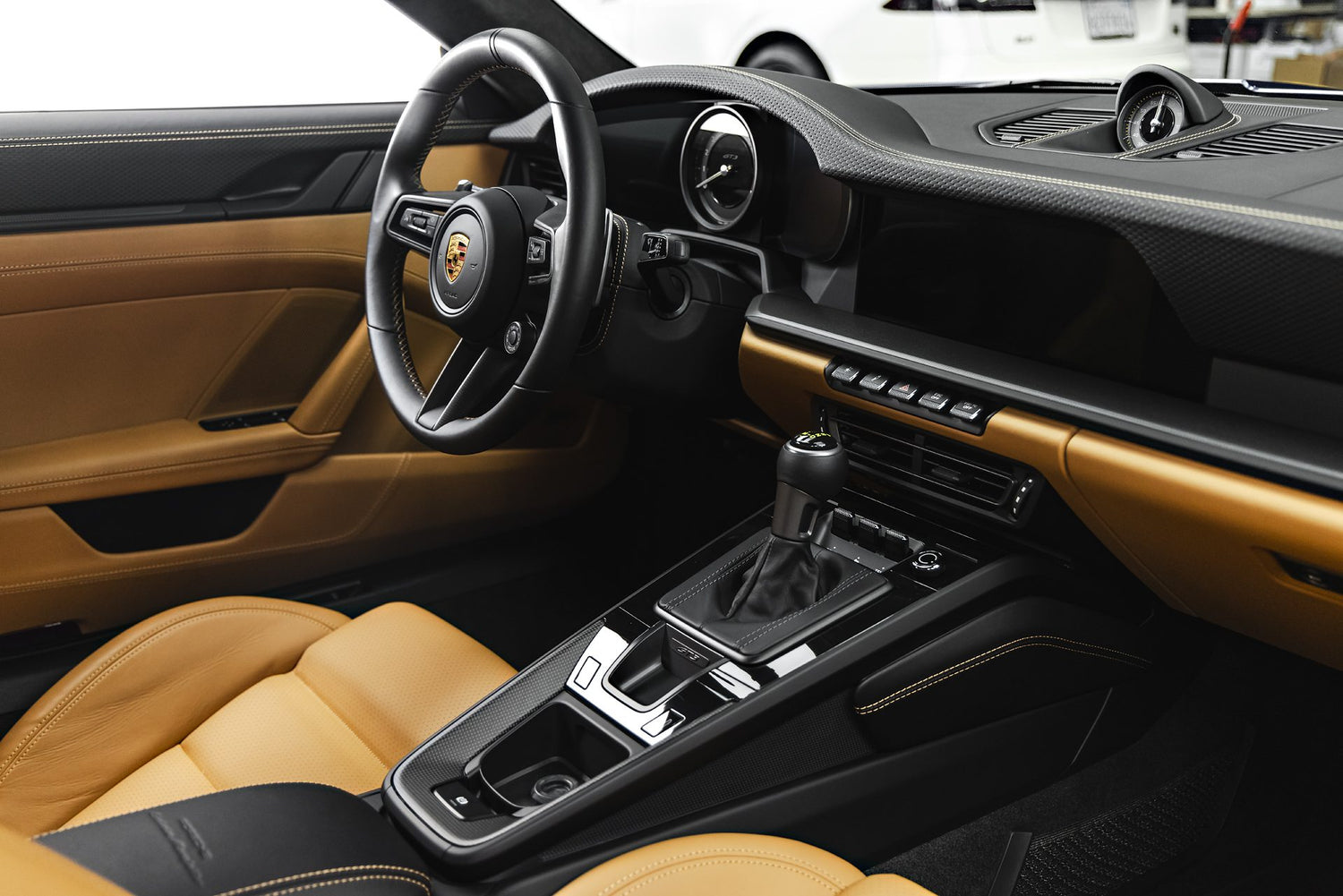 The meticulously detailed interior of a Porsche, showcasing the results of professional car detailing. This image highlights the clean leather seats, dashboard, and center console, demonstrating the high level of care provided by detailing near me. Notice the attention to detail on the steering wheel and gear shift, indicative of expert car detailing services. For premium car detailing near you that achieves this level of interior refinement, consider a professional service.