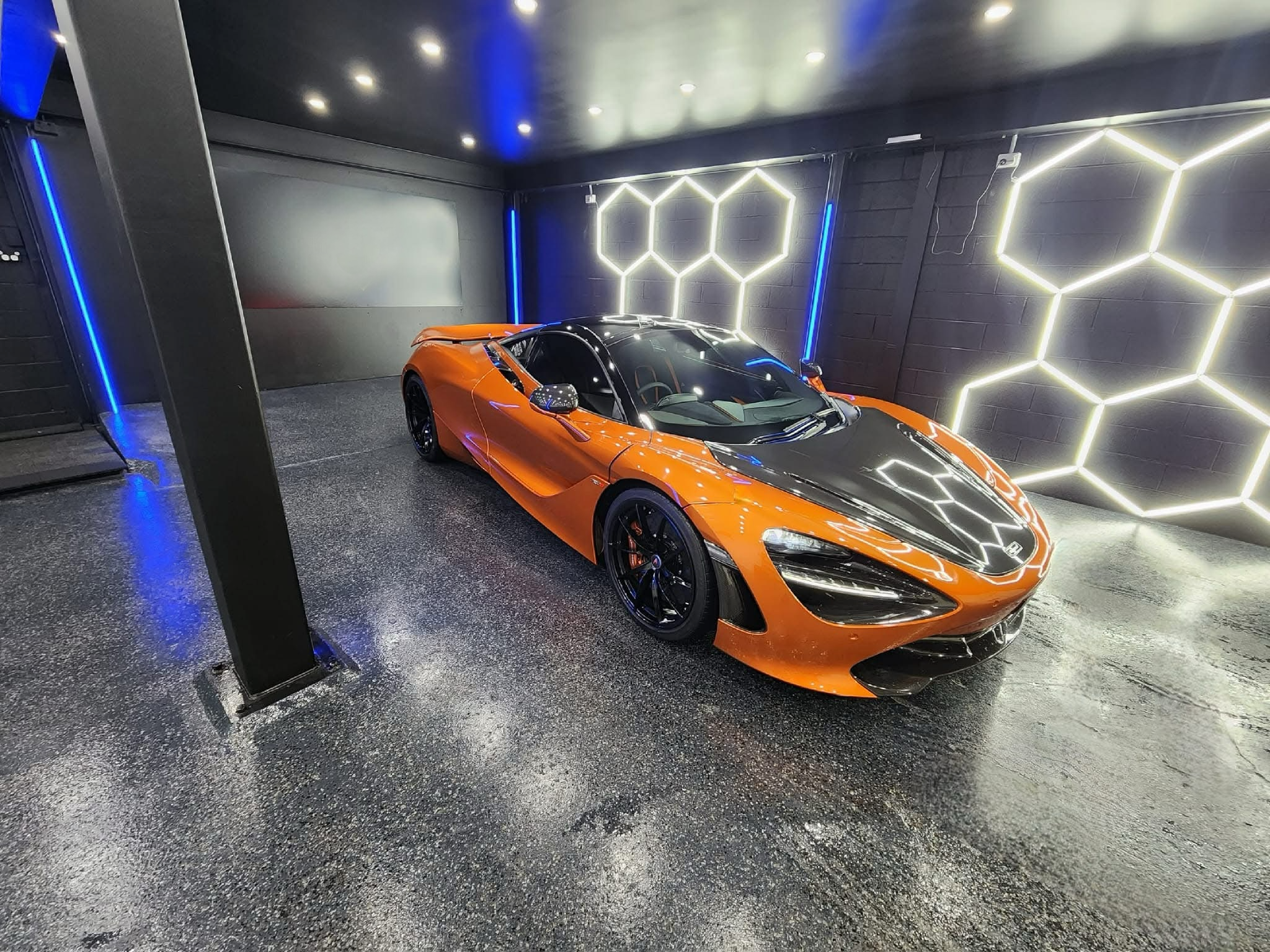 A vibrant orange McLaren, likely a 720S showcasing the exceptional gloss and depth achieved through a professional ceramic coating application and comprehensive car detailing at our center in Western Sydney, Chipping Norton. The image highlights the mirror-like finish on the paint and the meticulous detailing of the carbon fiber elements, demonstrating the high-quality ceramic coating and car detailing services available near you in Western Sydney. If you're looking for premium ceramic coating.