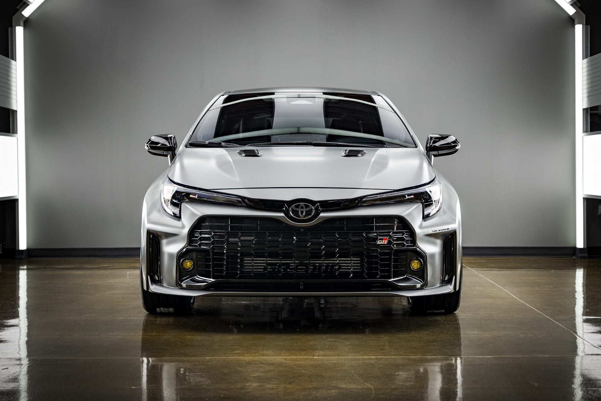 A front view of a silver Toyota GR Corolla, likely the 2023 or 2024 model, showcasing the enhanced shine and protection achieved through a professional ceramic coating application in Sydney, Chipping Norton, Western Sydney. The glossy finish highlights the benefits of a ceramic coating service available near you. Consider a ceramic coating near me to maintain your Toyota GR Corolla's appearance and protect it from the elements.