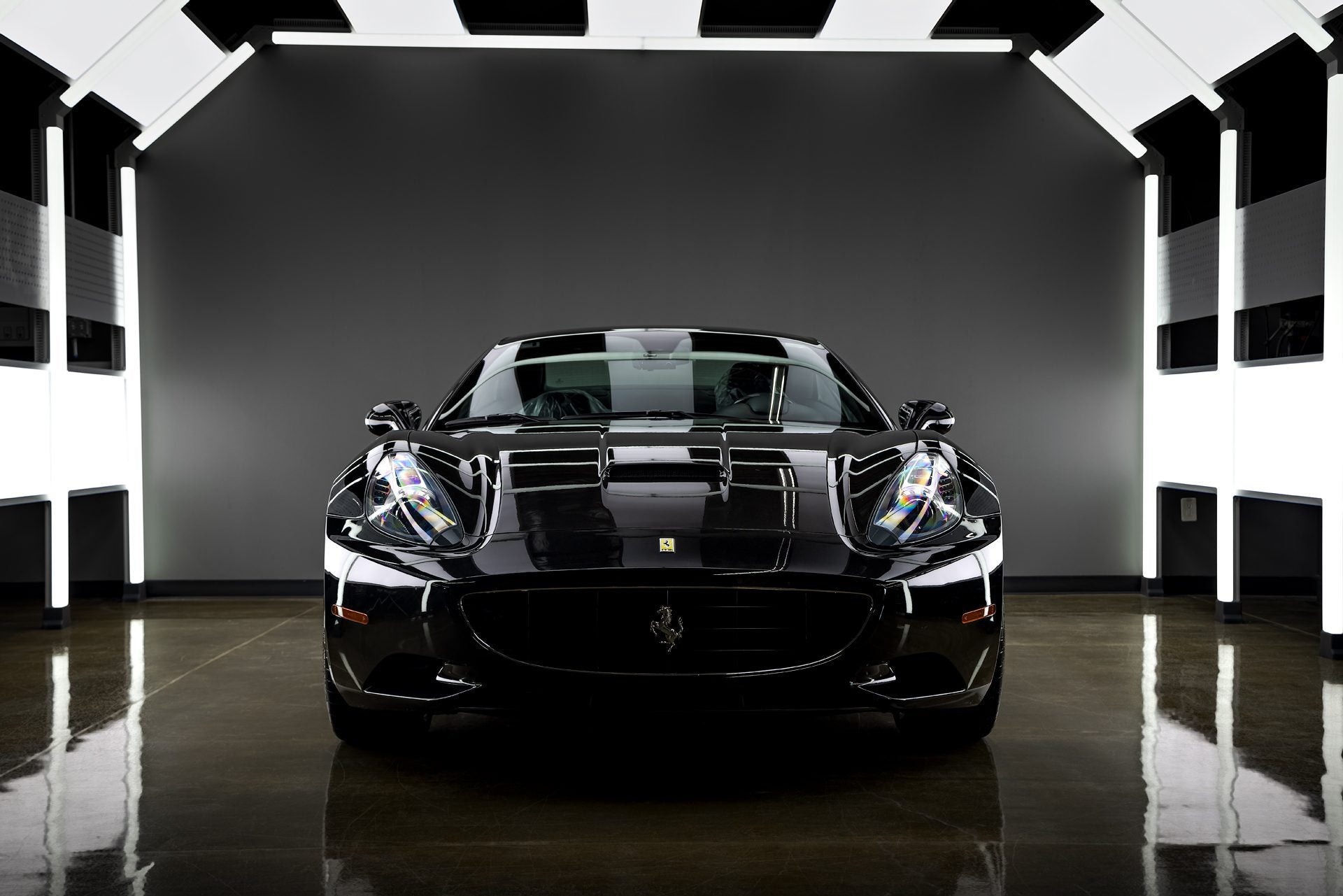 A front view of a sleek black Ferrari, showcasing the exceptional gloss achieved through a professional ceramic coating application at our detailing center in Western Sydney, Chipping Norton. The deep, reflective finish highlights the protective benefits of a high-quality ceramic coating service available near you in Western Sydney. If you're looking for premium ceramic coating near me in Chipping Norton to enhance and protect your Ferrari, this image exemplifies  the stunning results we can deliver